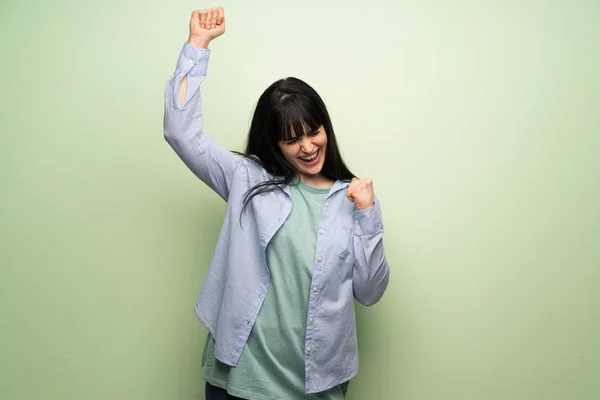 Young Woman Green Wall Celebrating Victory — Stock Photo, Image