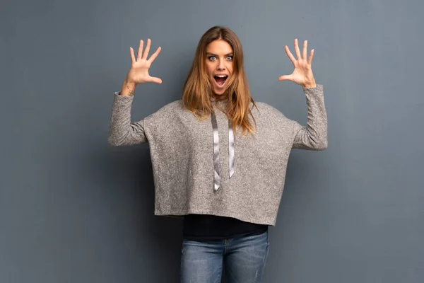 Mujer Rubia Sobre Fondo Gris Con Sorpresa Expresión Facial Impactada — Foto de Stock