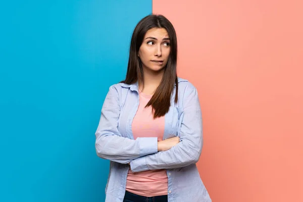 Junge Frau Über Rosa Und Blaue Wand Mit Verwirrtem Gesichtsausdruck — Stockfoto