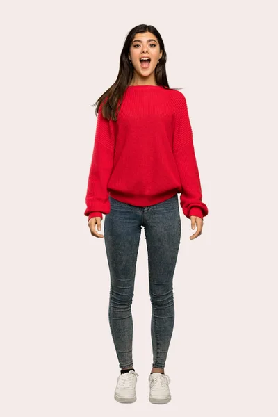 驚き表情分離の背景の上に赤いセーターとティーンエイ ジャーの女の子のフルレングス ショット — ストック写真