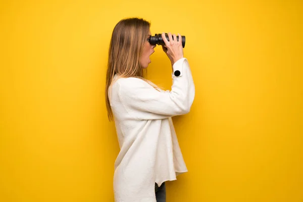 Blondýny Žena Přes Žlutou Stěnu Při Pohledu Dálky Dalekohledem — Stock fotografie