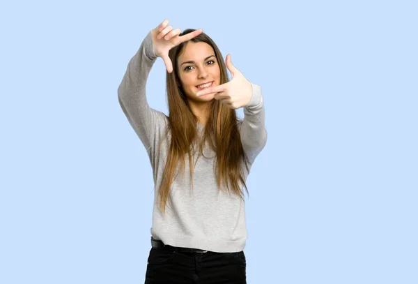 Young Girl Focusing Face Framing Symbol Blue Background — Stock Photo, Image