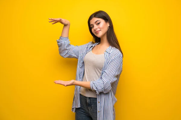 Teenager Mädchen Über Gelbe Wand Hält Kopierraum Eine Anzeige Einzufügen — Stockfoto