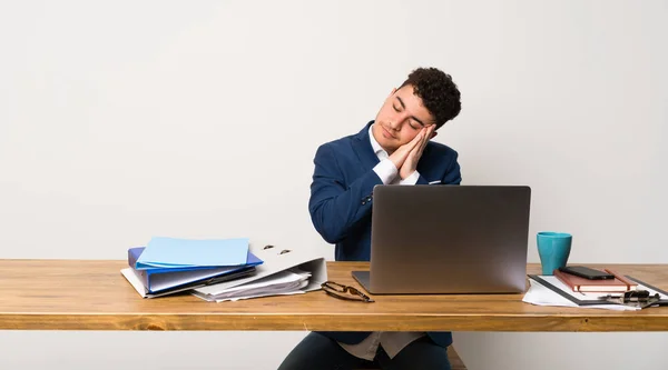 Business man in a office making sleep gesture in dorable expression