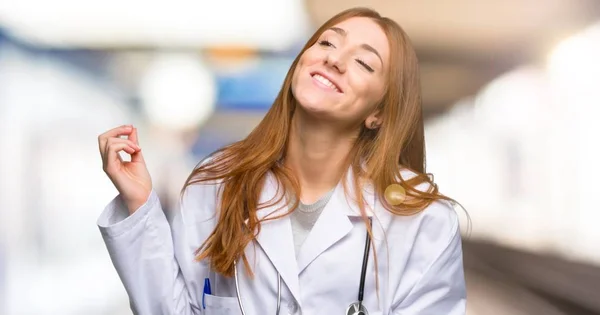 Redhead doctor woman enjoy dancing while listening to music at a party in the hospital