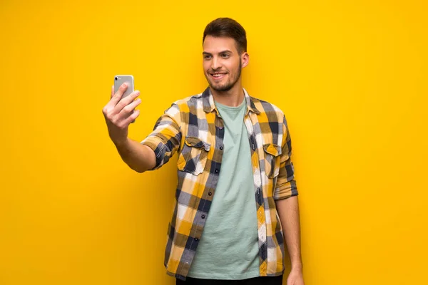 Schöner Mann Über Gelber Wand Macht Ein Selfie — Stockfoto