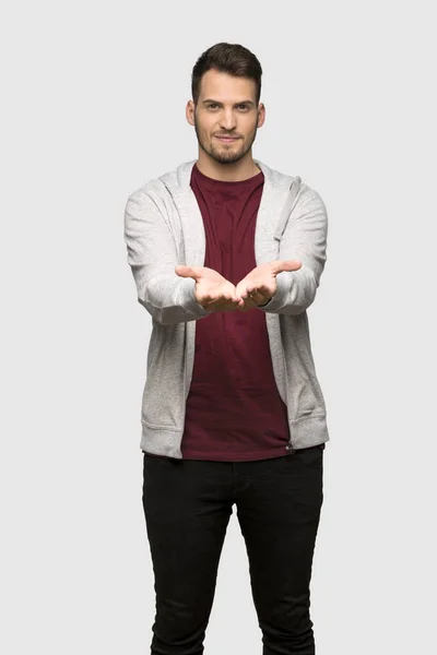 手红色衬衫的人拿着模仿空间想象在手掌上插入一个广告在灰色背景 — 图库照片