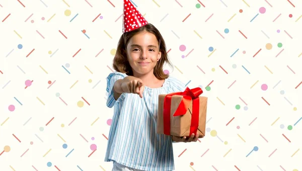 Niña Una Fiesta Cumpleaños Sosteniendo Dedo Puntos Regalo Fondo Colorido —  Fotos de Stock