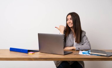İş kadını tarafına işaret eden bir ofiste bir ürün sunmak için