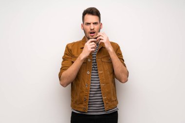 Beyaz duvar gergin ve korkmuş ellerini ağzına koyarak yakışıklı adam