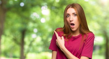 Şaşırttı ve yan parkta işaret eden genç Kızıl saçlı kız