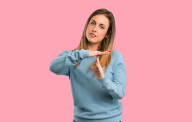 Mavi gömlek yapma dur jest eliyle sarışın kadınla bir hareket izole pembe durdurmak için