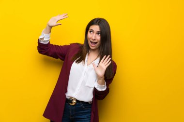 Gergin ve korkmuş sarı duvarın üzerinden genç kadın