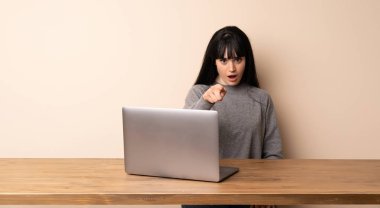 Onun laptop şaşırmış ve işaretleme açık ile çalışan genç kadın