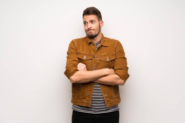 Beyaz duvar yapım şüpheler jest omuz kaldırma sırasında yakışıklı adam