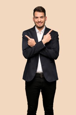 Koyu sarı arka plan üzerinde şüpheleri laterallerin işaret eden yakışıklı iş adamı