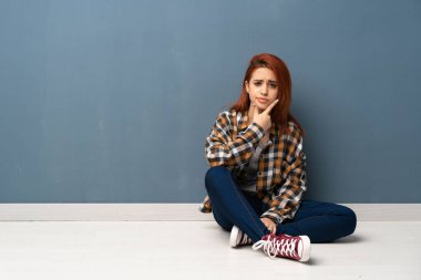 Yere düşünce oturan genç Kızıl saçlı kadın