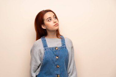 İzole arka plan ile ciddi bir yüz ararken genç Kızıl saçlı kadın