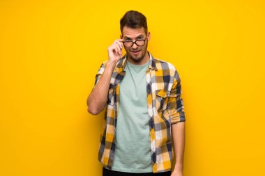 Sarı duvar gözlüklü ve sürpriz yakışıklı adam