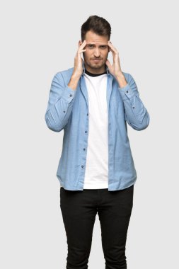 Yakışıklı adam gri arka plan üzerinde baş ağrısı ile