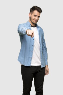 Sen, yakışıklı adam puan parmak gri arka plan üzerinde kendine güvenen bir ifade ile