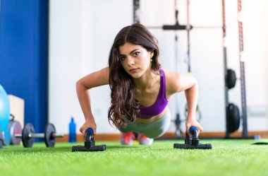 Genç kadın şınav bir spor salonunda spor