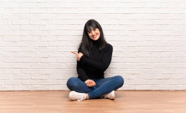 Ürün sunmak için tarafına işaret katta oturan kadın