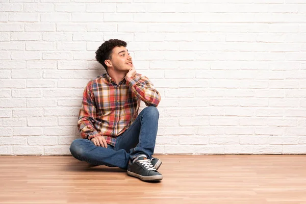Mladý Muž Sedí Podlaze Přemýšlí Zatímco Vzhlíží — Stock fotografie