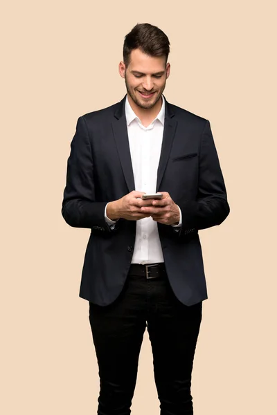 Schöner Geschäftsmann Sendet Eine Nachricht Mit Dem Handy Über Ockerfarbenem — Stockfoto