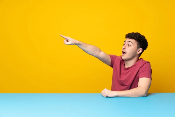 Jovem Com Parede Colorida Mesa Apontando Para Longe — Fotografia de Stock