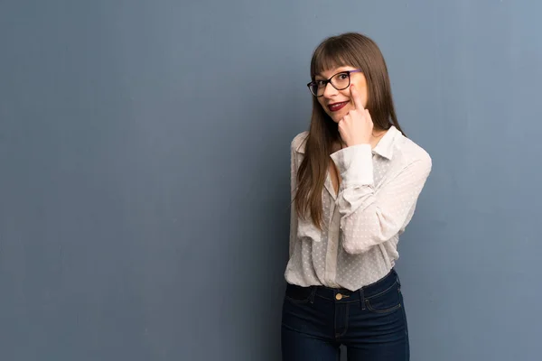 Mujer Con Gafas Sobre Pared Azul Mirando Frente — Foto de Stock