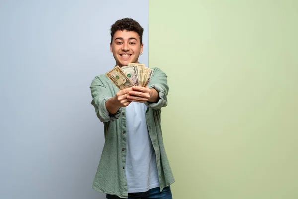 Joven Sobre Fondo Azul Verde Tomando Montón Dinero —  Fotos de Stock