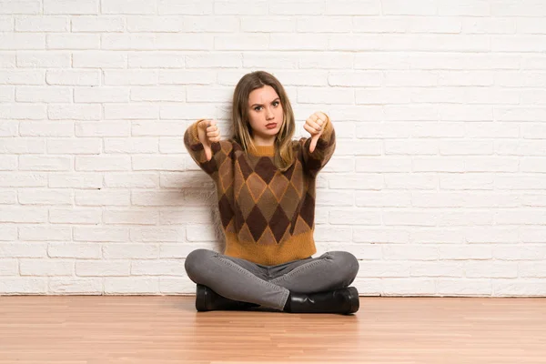 Teenager Mädchen Sitzt Auf Dem Boden Und Zeigt Daumen Dübel — Stockfoto