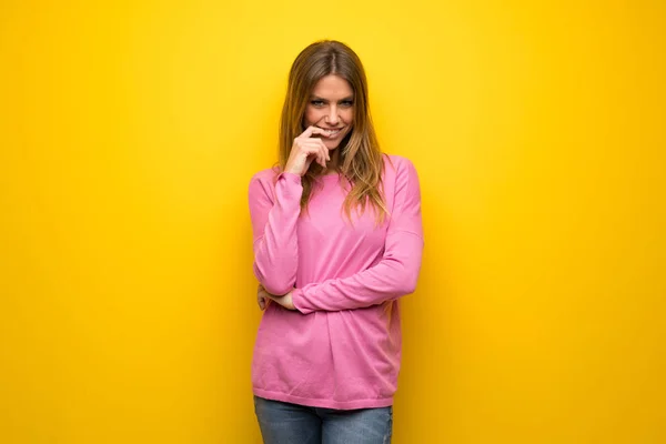 Vrouw Met Roze Trui Gele Muur Een Idee Denken Terwijl — Stockfoto