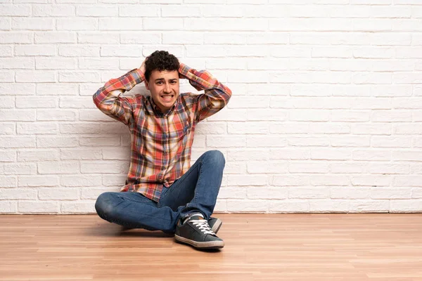 Mladý Muž Sedí Podlaze Frustrovaný Ruce Hlavu — Stock fotografie