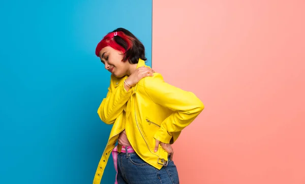 Young woman with yellow jacket suffering from pain in shoulder for having made an effort