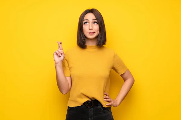 Iyi Dilek Geçiş Parmaklarıyla Sarı Duvarın Üzerinden Genç Kadın — Stok fotoğraf