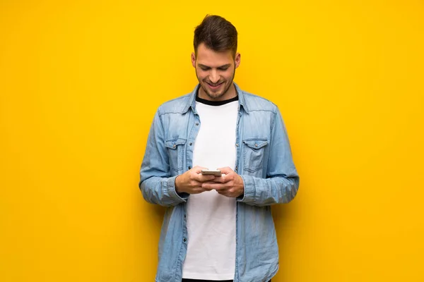 Schöner Mann Über Gelbe Wand Sendet Eine Nachricht Mit Dem — Stockfoto