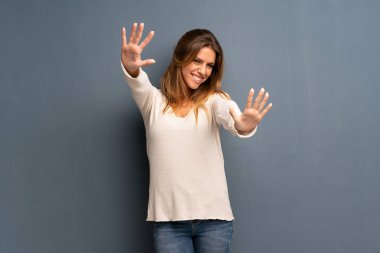 On parmak ile sayma gri arka plan üzerinde sarışın kadın