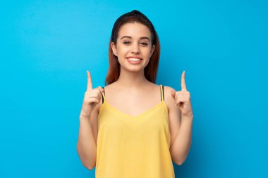 Harika bir fikir işaret parmağı ile mavi arka plan genç Kızıl saçlı kadın