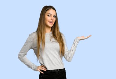 mavi arka plan bir reklamı eklemek için boşaltmak hayali avuç içinde tutan genç kız