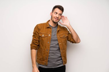 Beyaz duvar için bir şey kulak el koyarak dinleme yakışıklı adam