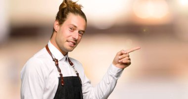 Adam bir kuaför dükkanı yatay konumda Side'de parmakla apronda berber