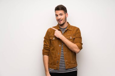 Beyaz duvar şaşırmış ve işaret parmak tarafa yakışıklı adam