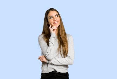 genç kız mavi arka plan üzerinde ararken bir fikir düşünüyorum