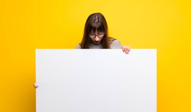 Kadın gözlük için boş bir afişini tutan sarı duvarın üzerinden bir kavram Ekle