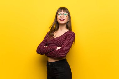 Üzerinde çarpı işareti silah ile sarı duvar ve dört gözle gözlüklü kadın