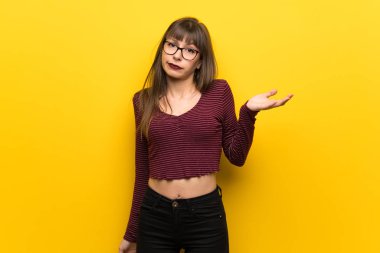 Sarı duvar eller yükselterek süre şüpheleri üzerinden gözlüklü kadın
