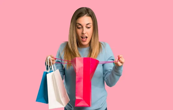 Blonde Vrouw Met Blauwe Shirt Verrast Terwijl Een Heleboel Boodschappentassen — Stockfoto