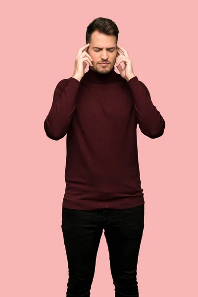 タートルネックのセーターを挫折とピンクの背景を手で覆って耳の男 — ストック写真